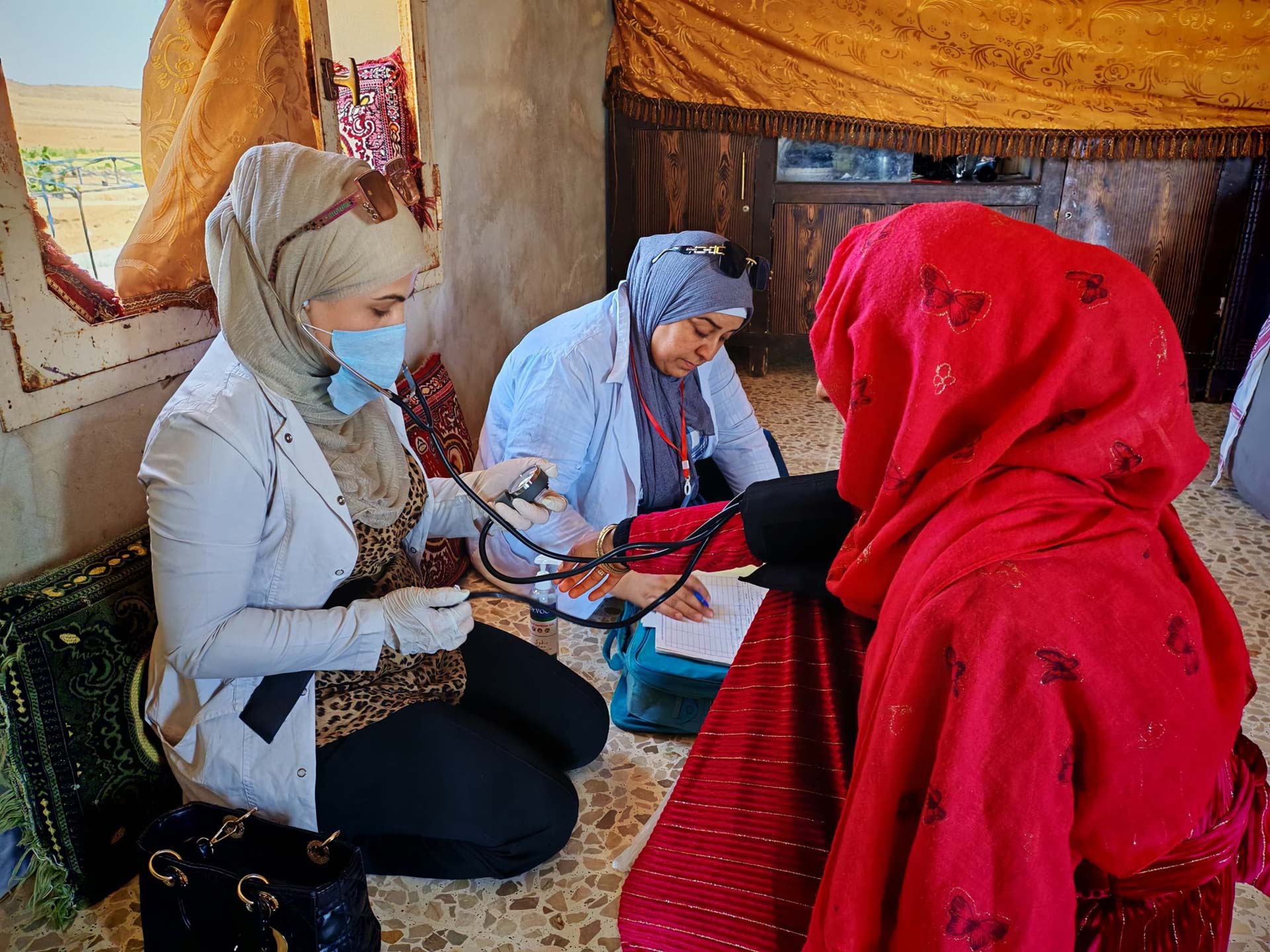 A WHO-supported mobile health team from Al Bir checks the blood pressure of a woman during a home visit in rural Hama. Mobile clinics provide essential health services to families who would otherwise struggle to access care.   Photo credit: WHO