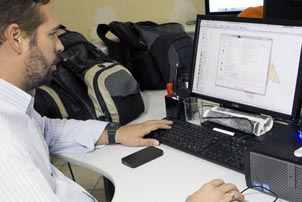 La photo nous montre un homme travaillant sur un ordinateur