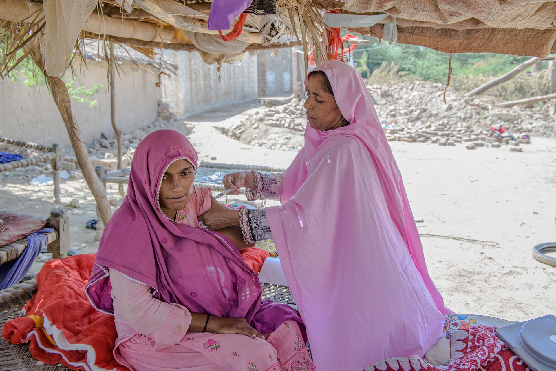 A health worker administers a vaccine to a woman in a rural community as part of efforts to expand immunization coverage in hard to reach areas