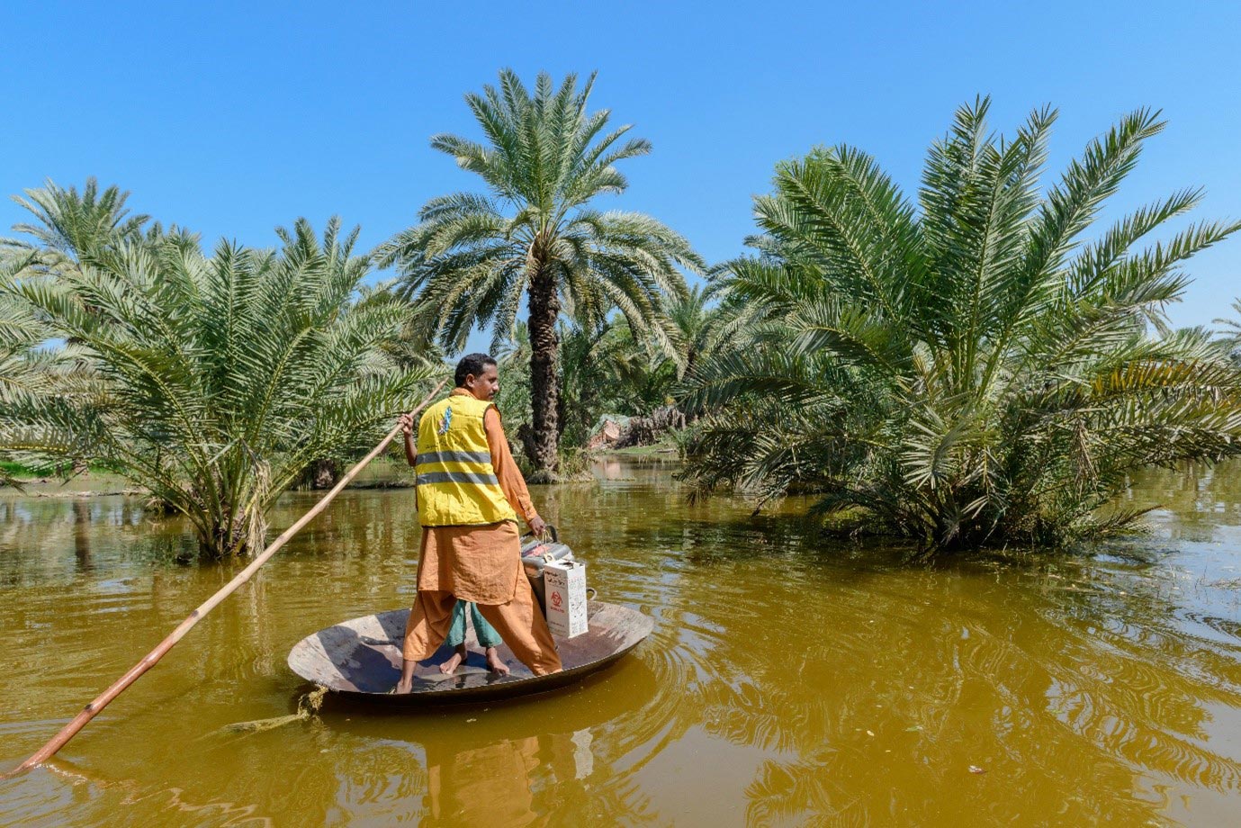 A health worker transports vaccines by boat to reach communities affected by flooding