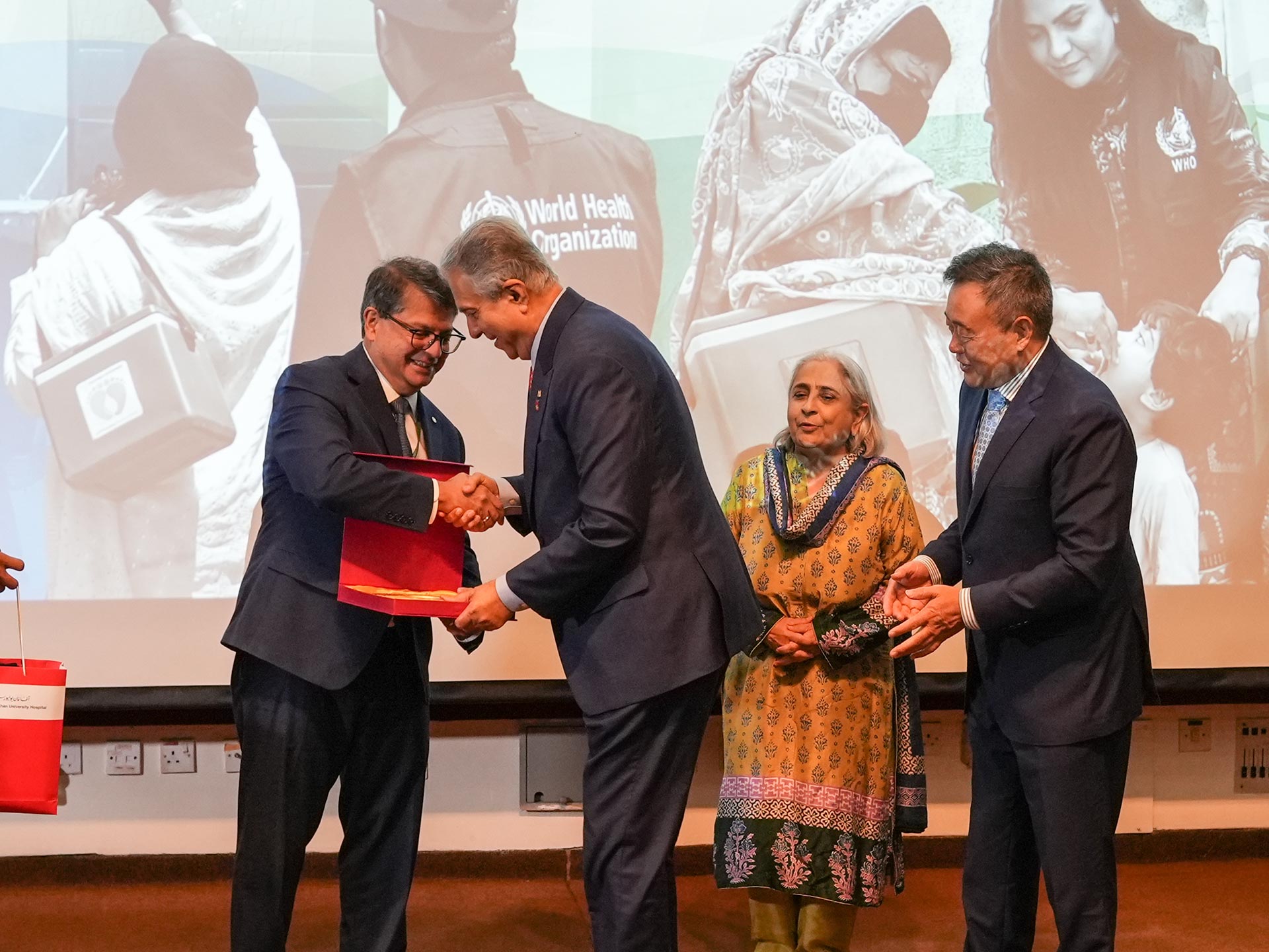 WHO Pakistan Representative Dr Luo, Dean of Aga Khan University Medical College Dr Karim F. Damji and Sindh's Health State Minister Azra Fazal Pechuho. present a recognition shield to Mr. Aziz Memon, Chairman of the National Polio Plus Committee for Rotary International during the event “The last mile to polio eradication.” Photo credit: AKU.