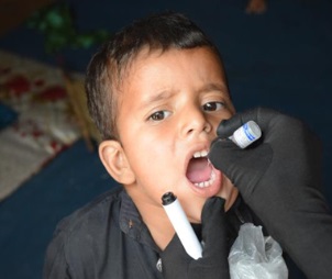 A child receives two drops of polio vaccine during the May vaccination campaigns in Lahore, Pakistan. WHO Pakistan/Anam Khan.
