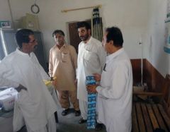 A DEWS surveillance officer and the district health office team discuss water filtration and purification in Kech district following the earthquake