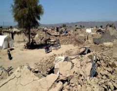 A scene of devastation following the earthquake with houses destroyed and people living outdoors