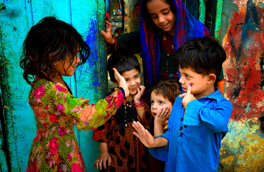 أطفال يظهرون أصابعهم المميزة بعلامة تلقي جرعة من لقاح شلل الأطفال خلال أيام التمنيع دون الوطنية في آب/ أغسطس 2021 في لاهور، باكستان. سيد مهدي بخاري، منظمة الصحة العالمية 