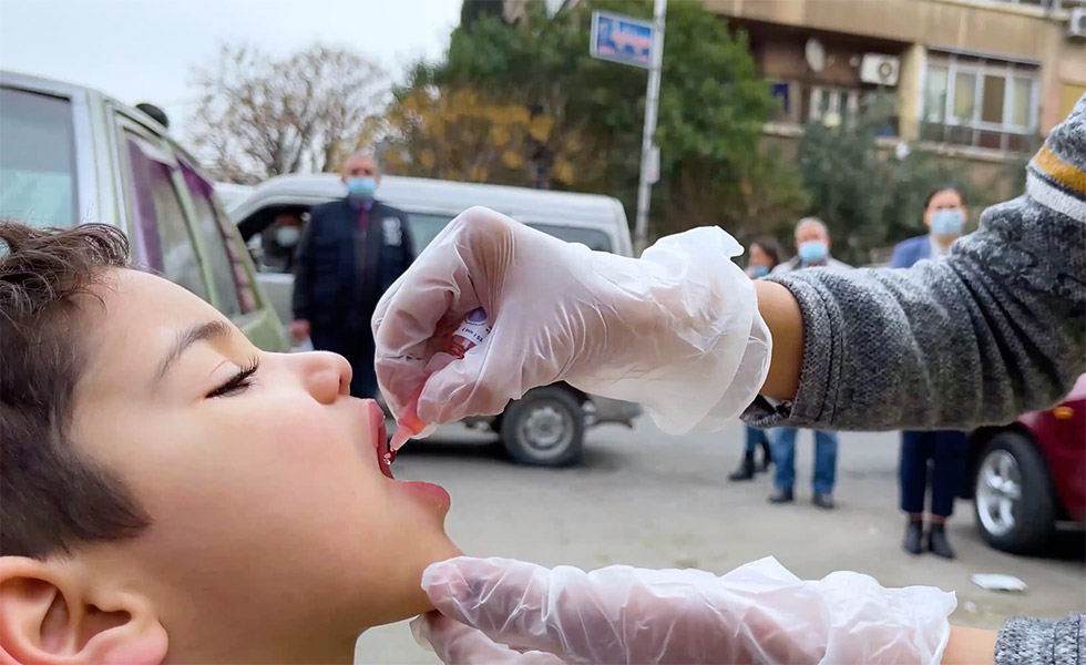 A child receives polio vaccine during the national polio immunization campaign concluded in March 2021, reaching 2.5 million children under the age of five in all 14 governorates of Syria, including high-risk areas of the eastern Euphrates, refugee and IDP camps, and nomadic areas.