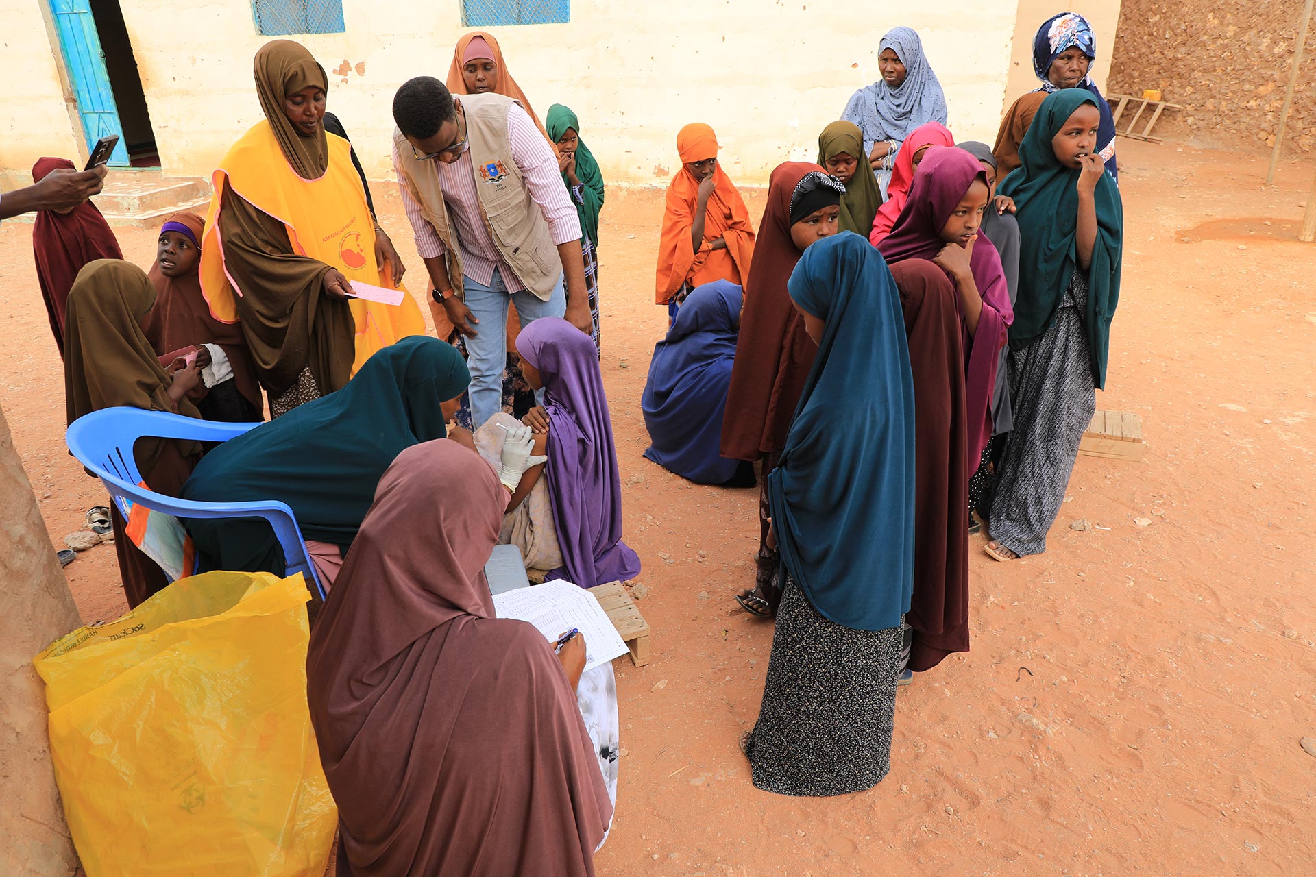 A child receives a vaccine during the diphtheria campaign in Dhusamareeb, Somalia, as other Madrasa students wait in line. Photo credit: Diini Abdi Diini