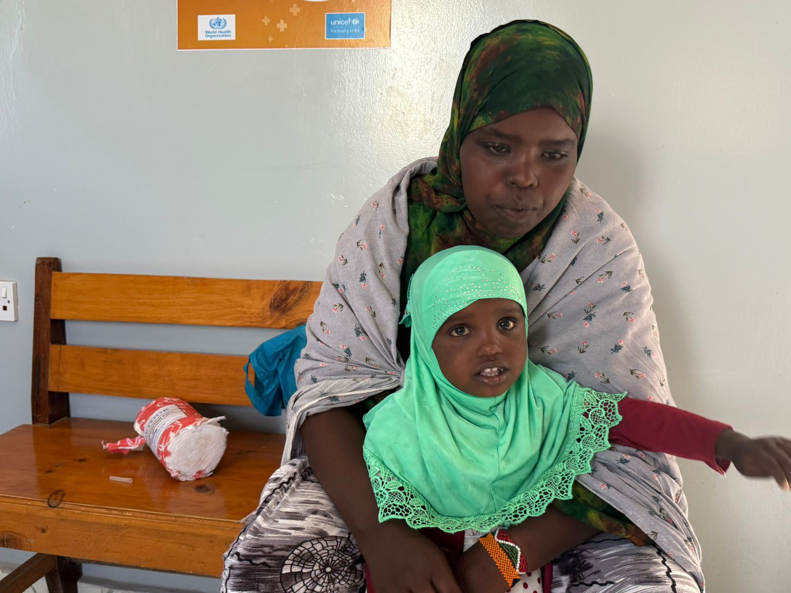 Hamda Awil Jama cradles her daughter, Masna, as they wait for her turn to receive the vaccine at the Maternal and Child Health (MCH) center in Toon village. Photo credit: WHO, Khadar Hared