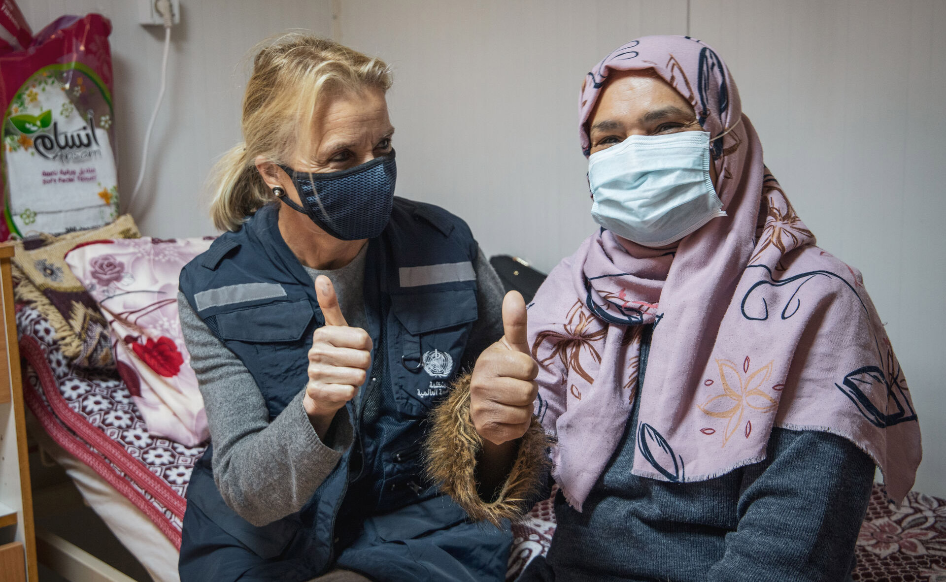 WHO representative in Libya sitting with a TB patient