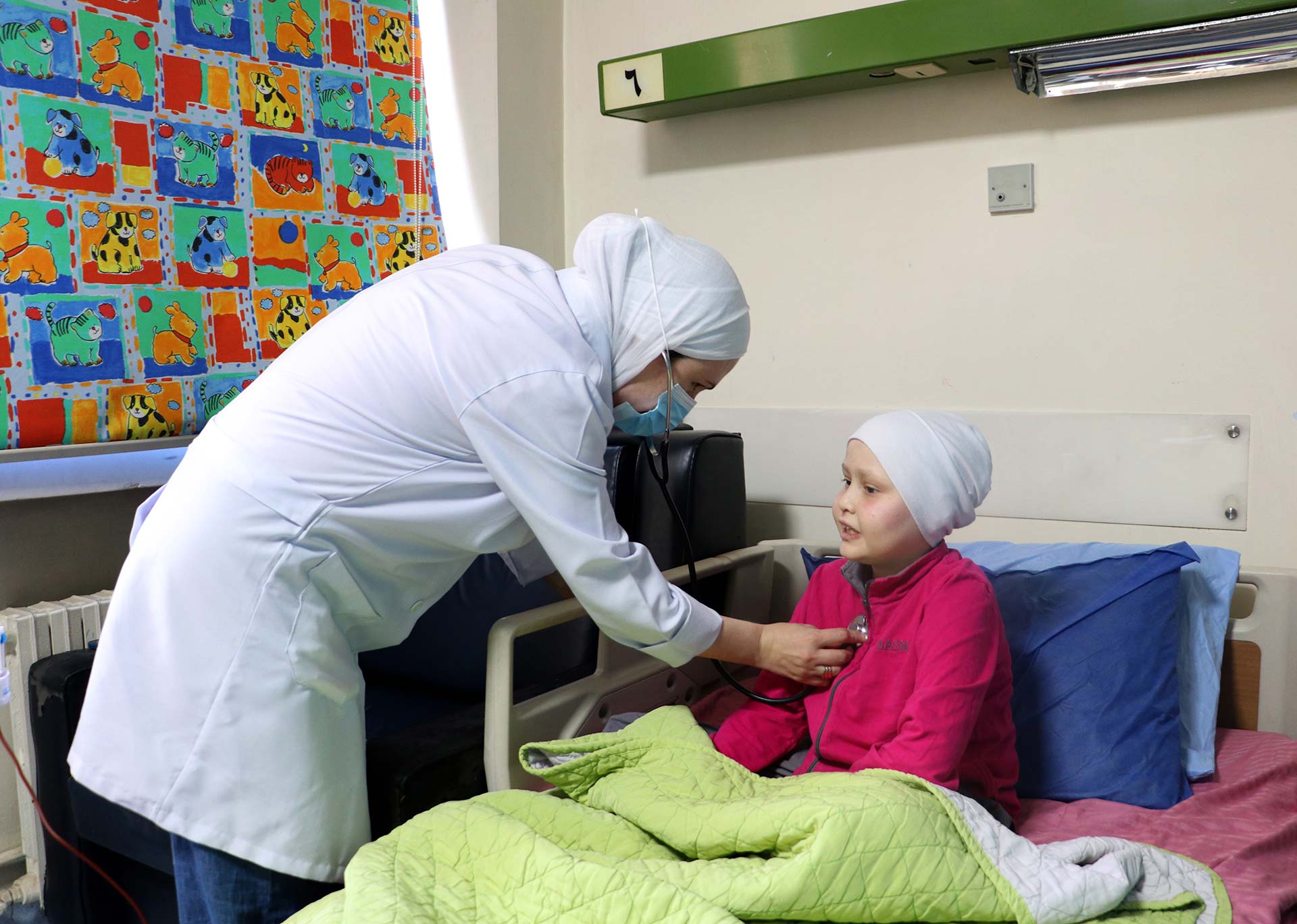 At Al-Bairouni University Hospital in Damascus, 11-year-old Zahraa receives a routine check-up from a pediatric oncology nurse during her chemotherapy treatment. At Al-Bairouni University Hospital in Damascus, 11-year-old Zahraa receives a routine check-up from a pediatric oncology nurse during her chemotherapy treatment. Photo credit: WHO