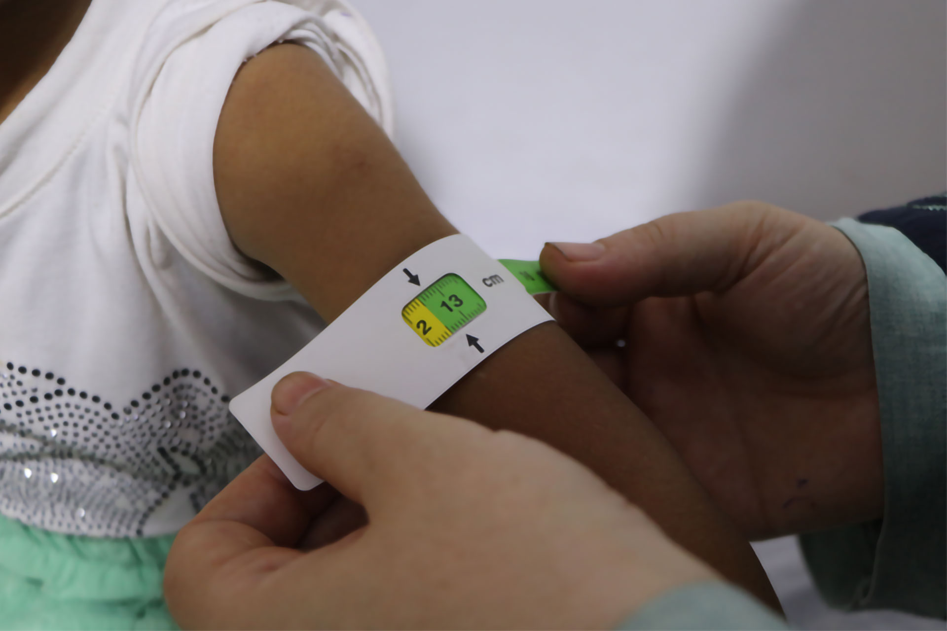 A close view of a mid-upper arm circumference measurement taken during Mona’s health assessment. Photo credit: WHO