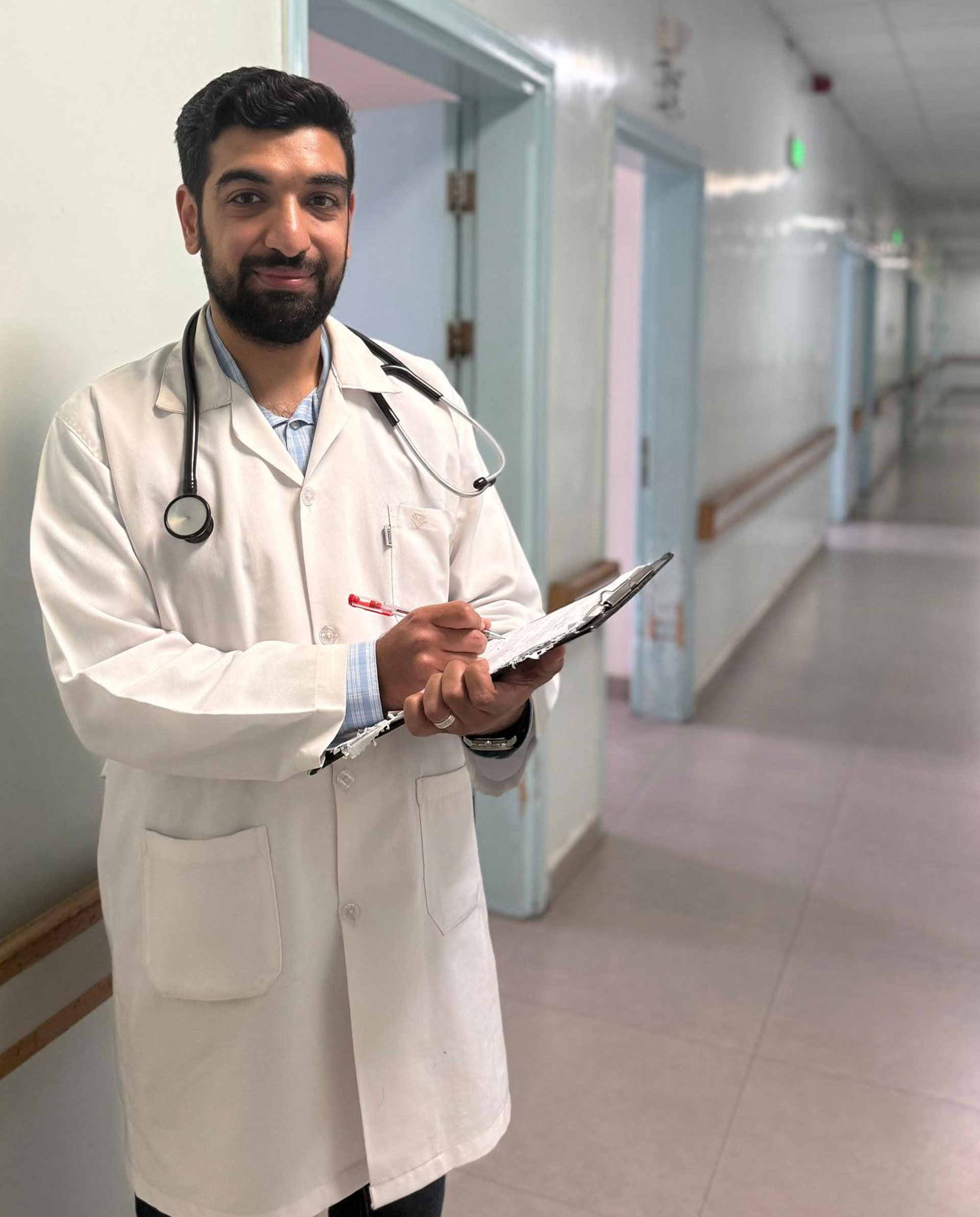 In Homs, Dr Malek Al-Aweer reviews a patient chart while standing in the hospital corridor. Photo credit: WHO