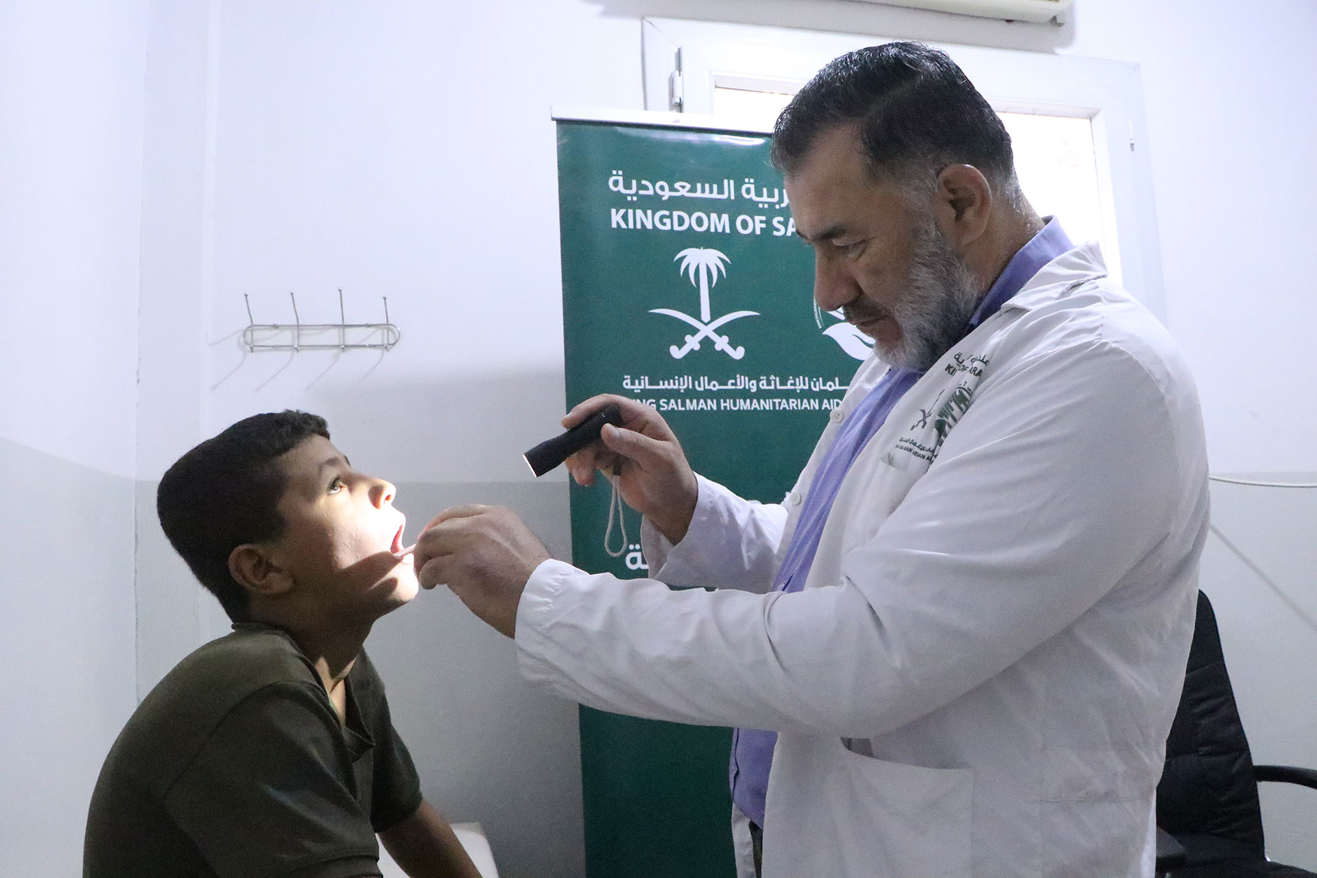 Dr. Mustafa Hamdan Kareem examines Mohammad Bilal Al-Qasem during a consultation at Qareh Koubré Health Centre in Aleppo. Photo credit: WHO 
