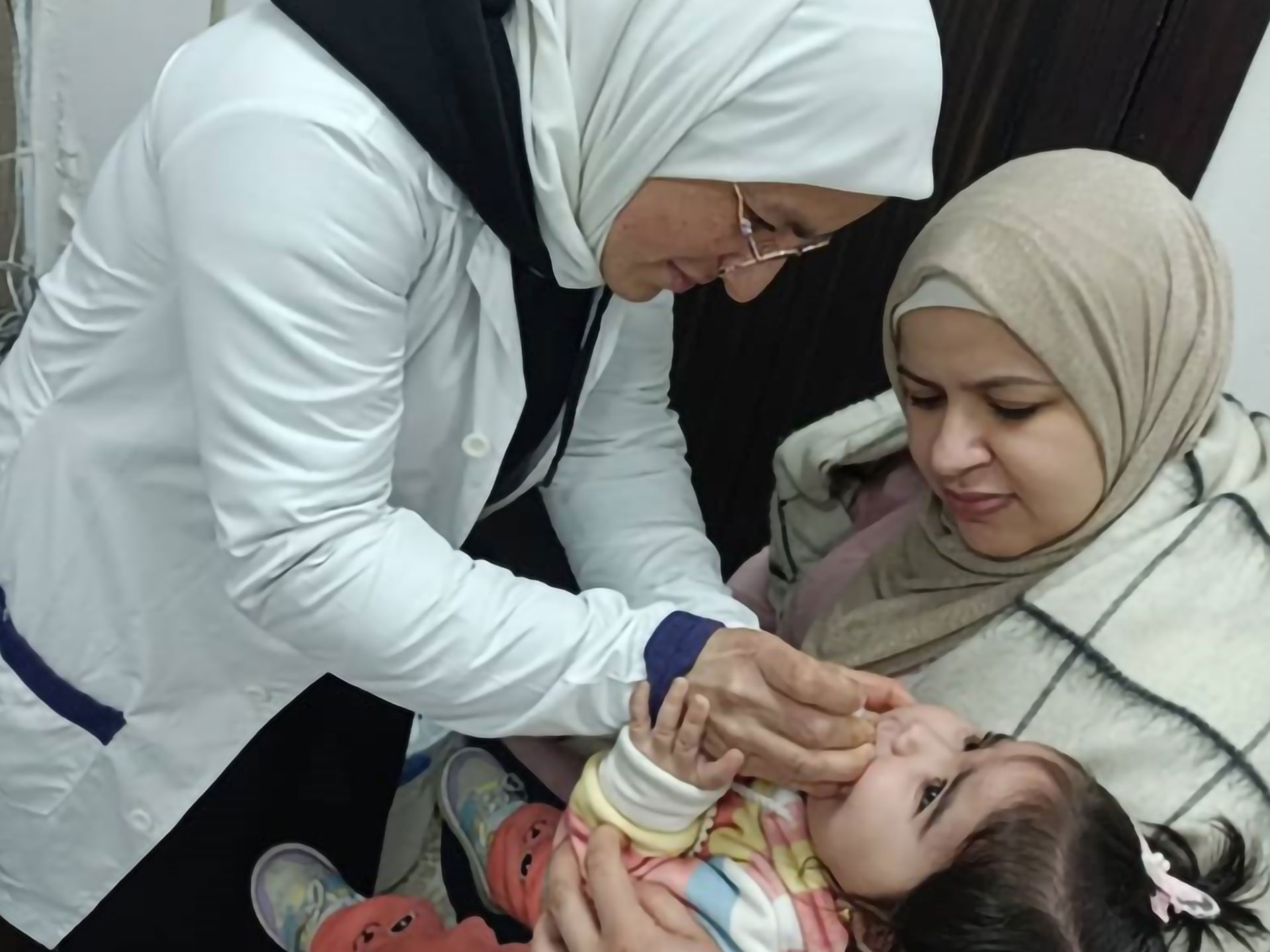 Dr Ruba Shaalan Atasi administers a vaccine to a child in Homs as part of ongoing immunization efforts. Photo credit: WHO