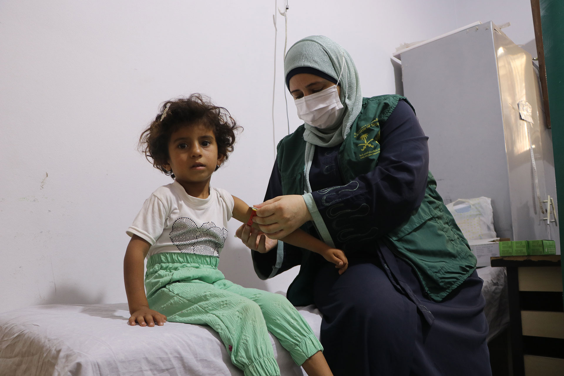 Dumoo’ measures Mona Talrafadi’s mid-upper arm circumference during a routine growth-monitoring. Photo credit: WHO