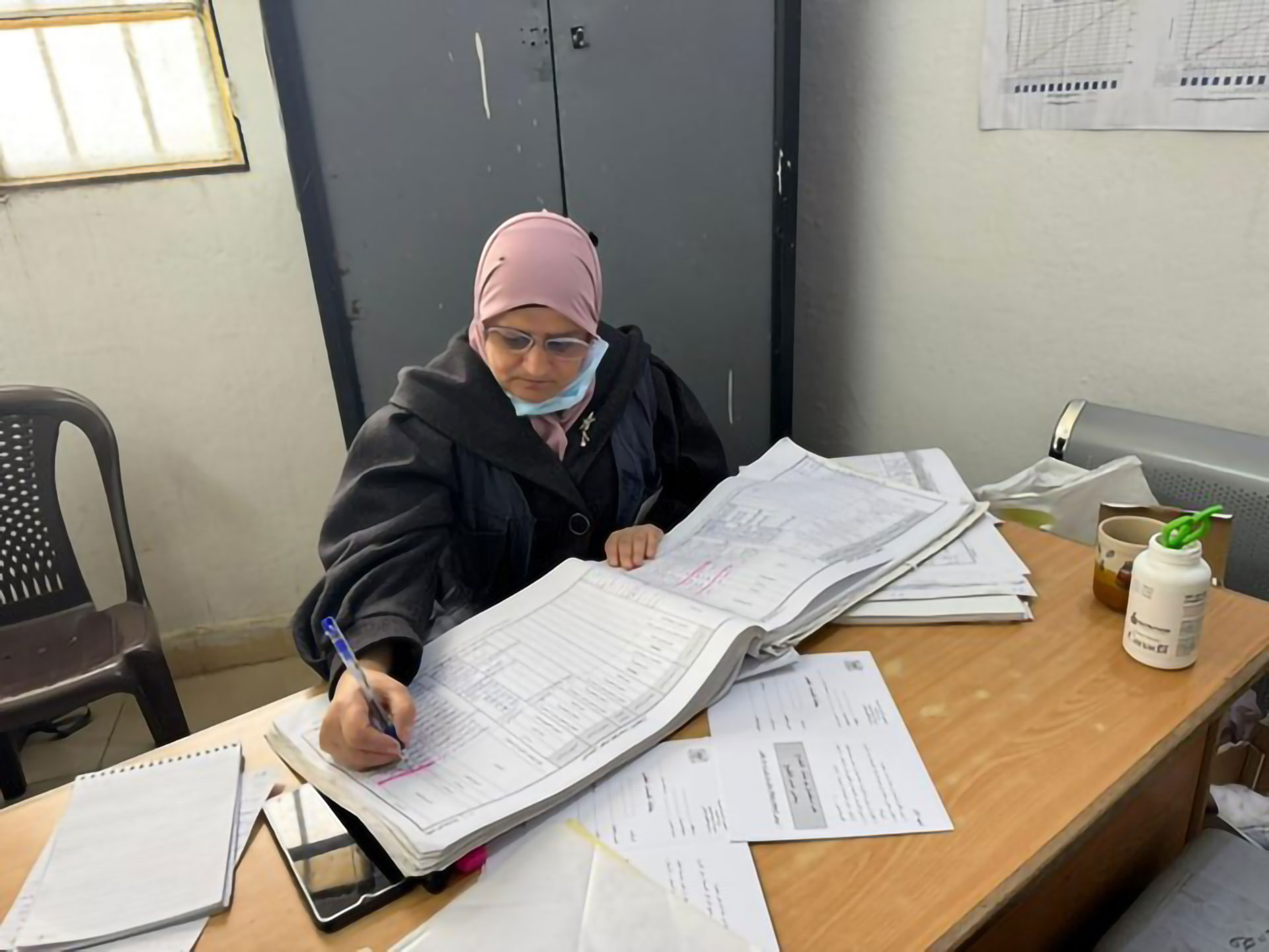 Ghofran Khozam, a vaccination focal point in Deir-ez-Zor, reviews records as part of efforts to ensure children receive life-saving vaccines. Photo credit: WHO