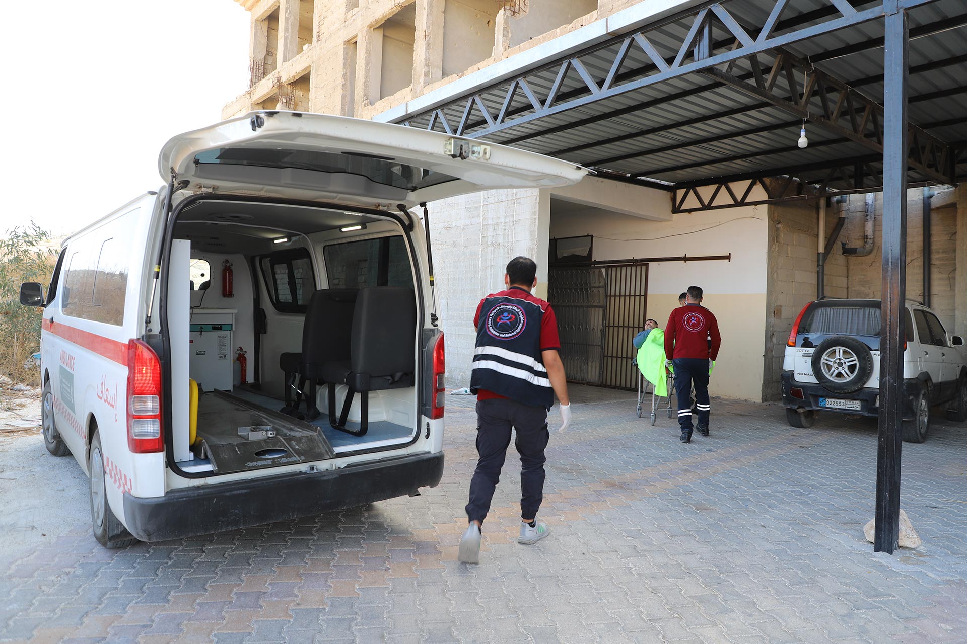 Musaab Abdulwahab Al-Yaqoub responds to an emergency call in Idlib, transferring a patient from a newly delivered ambulance to a health facility under the Central Referral and Ambulance System. Photo credit: WHO