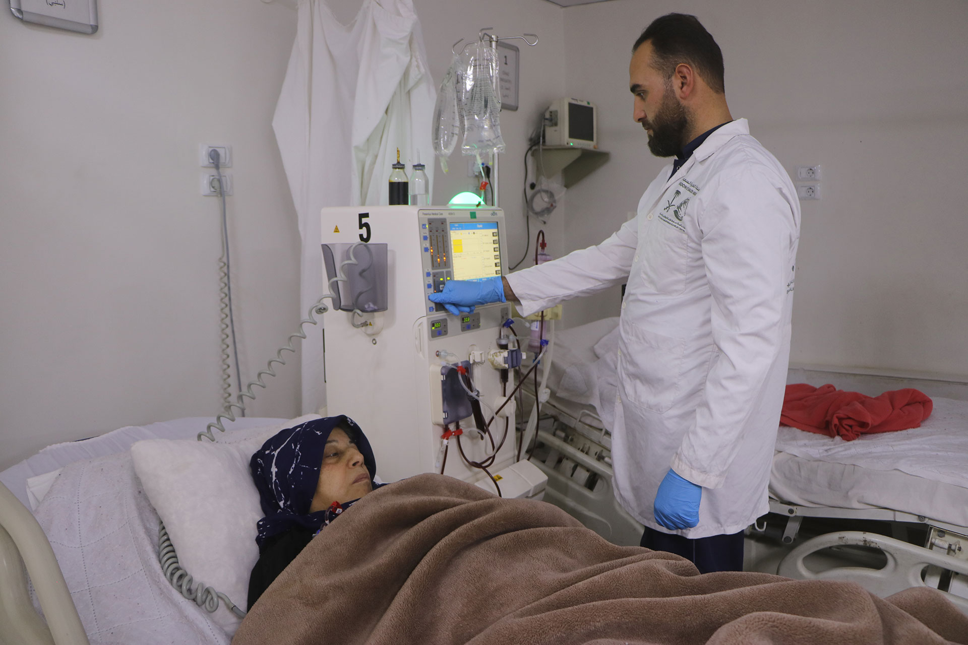 Sabah Al-Ahmad receives dialysis care from nurse Abd al-Rouf Saqqar at Azaz National Hospital. Photo credit: WHO  