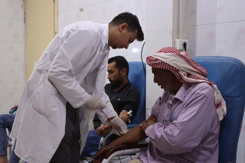 Laboratory technician Abdel Salam Khalaf collects blood from a donor at Menbij National Hospital that was supported by WHO. Photo credit: WHO
