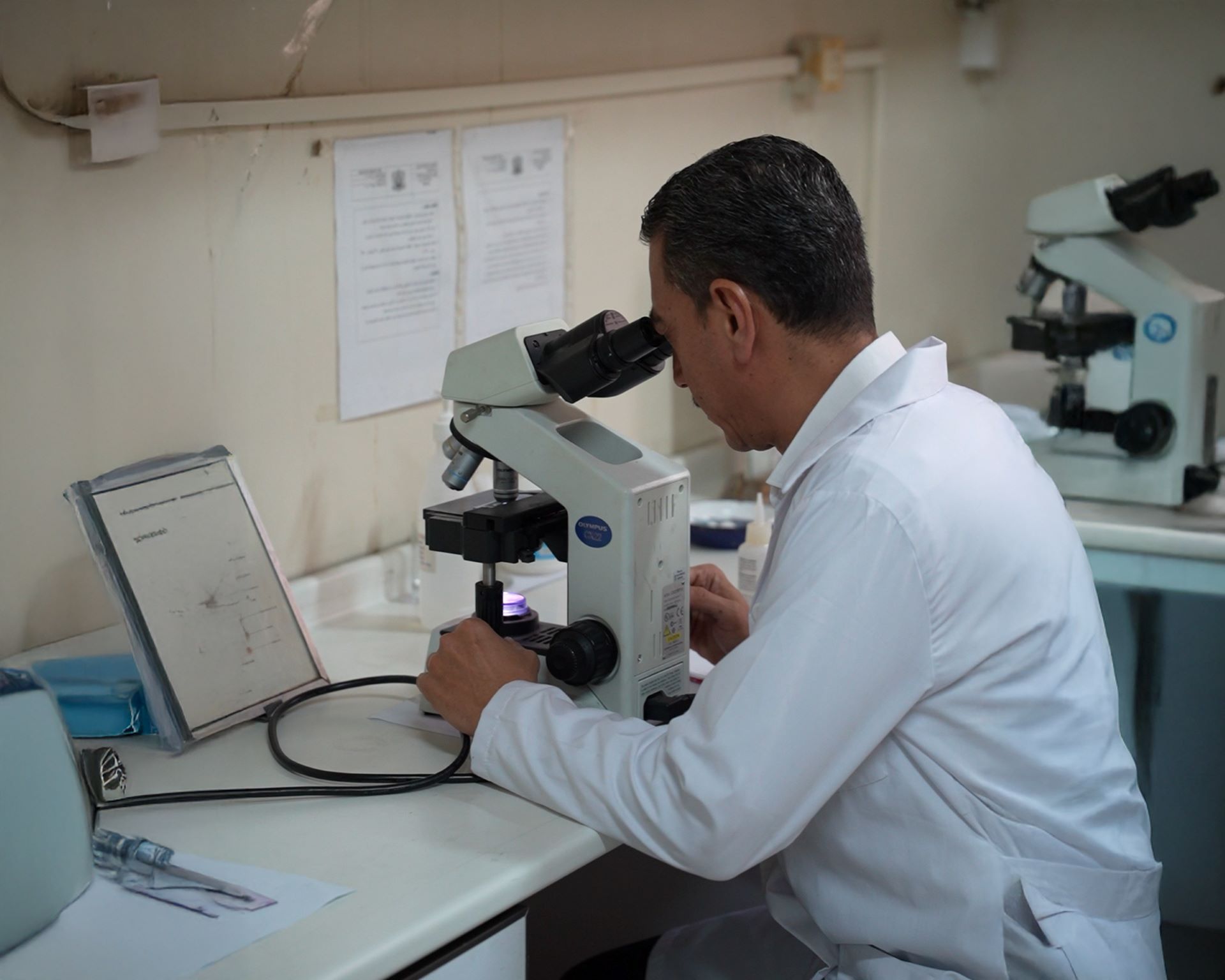Dr Wasim Battah, Director of Laboratories and Medical Tests at the Ministry of Health, examines a sample at the laboratory. Photo credit: WHO