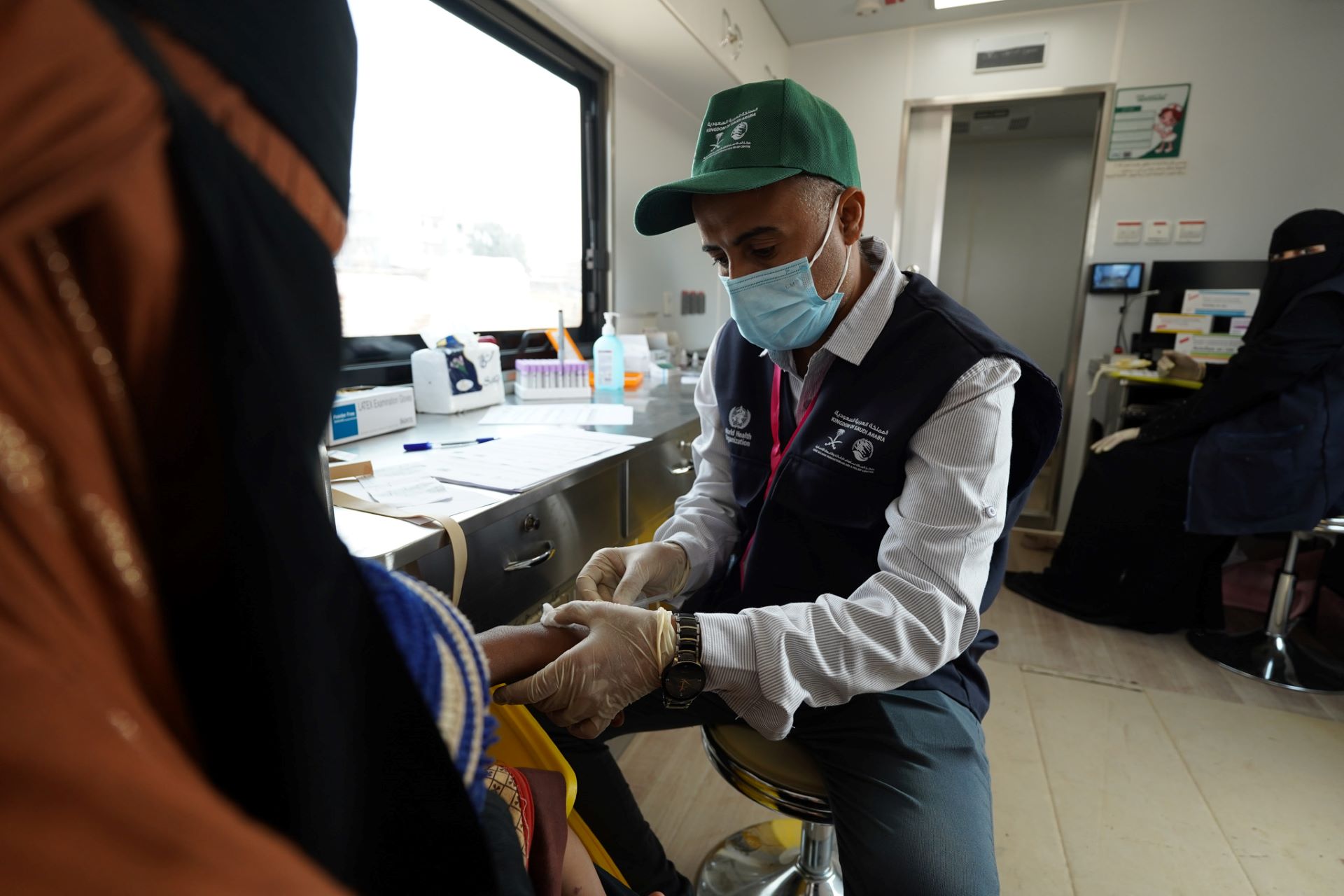 A mother and her child are being examined by the mobile health team as part of the malaria screening and treatment services provided in the IDP camp. Photo credit: WHO Yemen